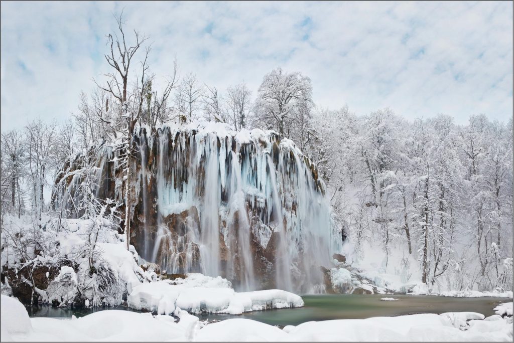 Slap okružen snijegom u Nacionalnom parku Plitvička jezera tijekom zimskog razdoblja