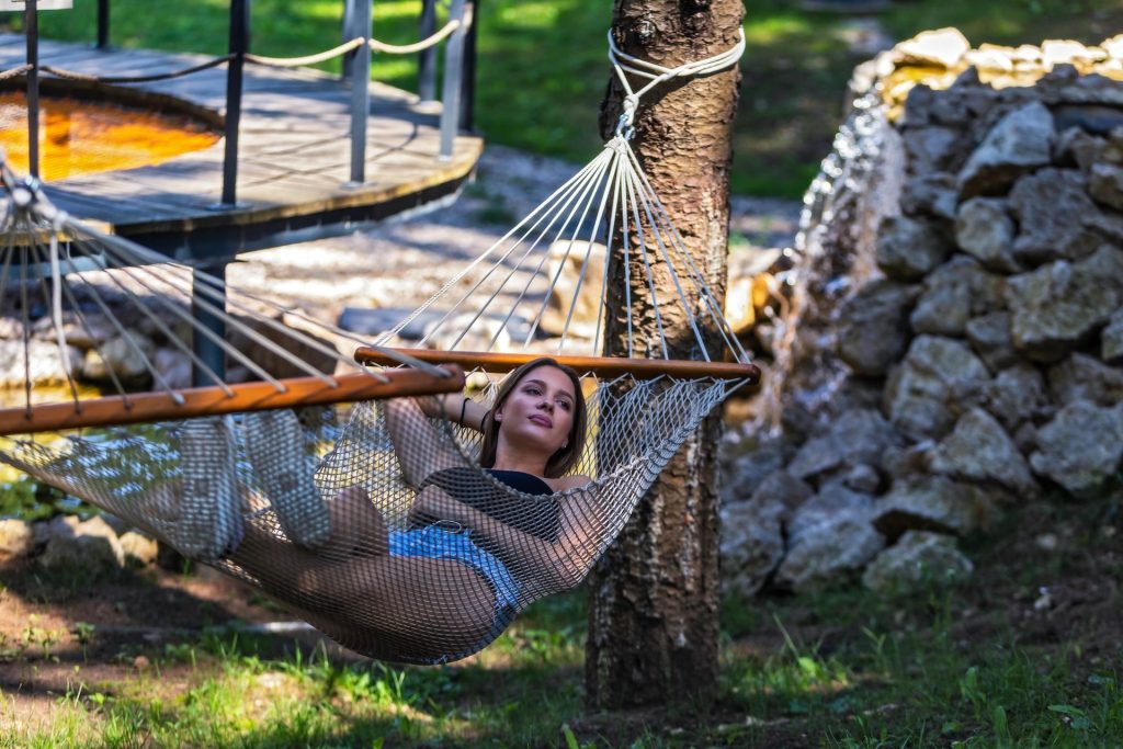 Žena odmara u visećoj mreži u prirodnom okruženju unutar Plitvice Holiday Resorta